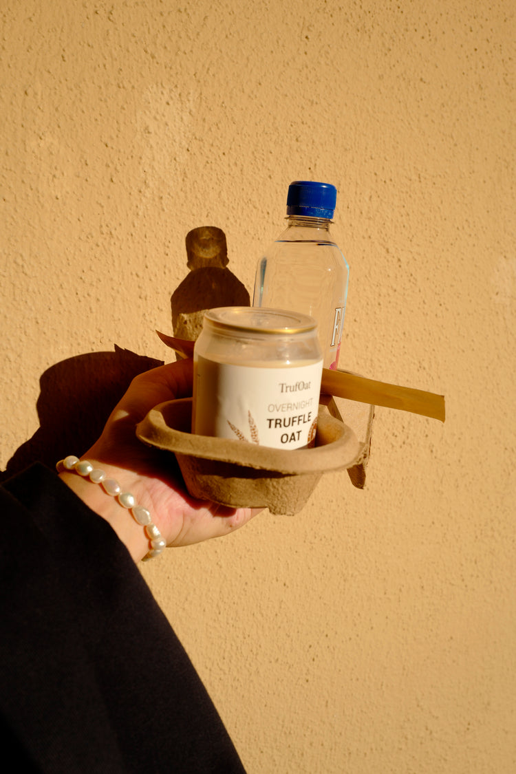 A woman carrying a can of TrufOat after a morning workout